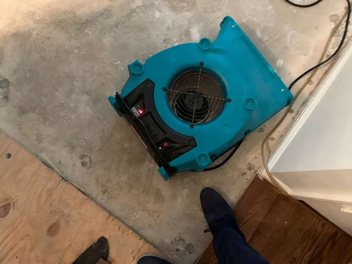 Air mover drying subfloor during Commercial Water Damage Restoration in Kings Grant